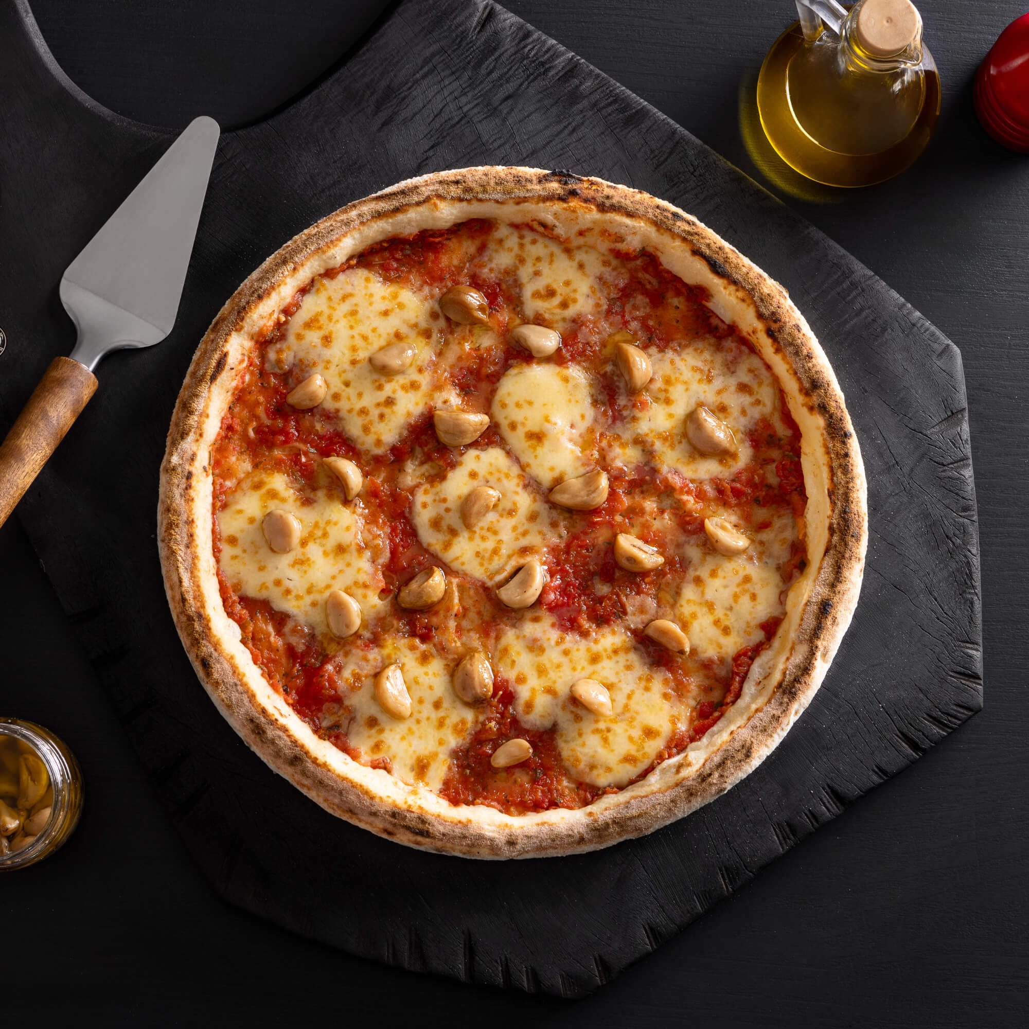 Pizza de alho confitado com massa de fermentação lenta de 48 horas, molho artesanal, queijo derretido e alho confitado no azeite.