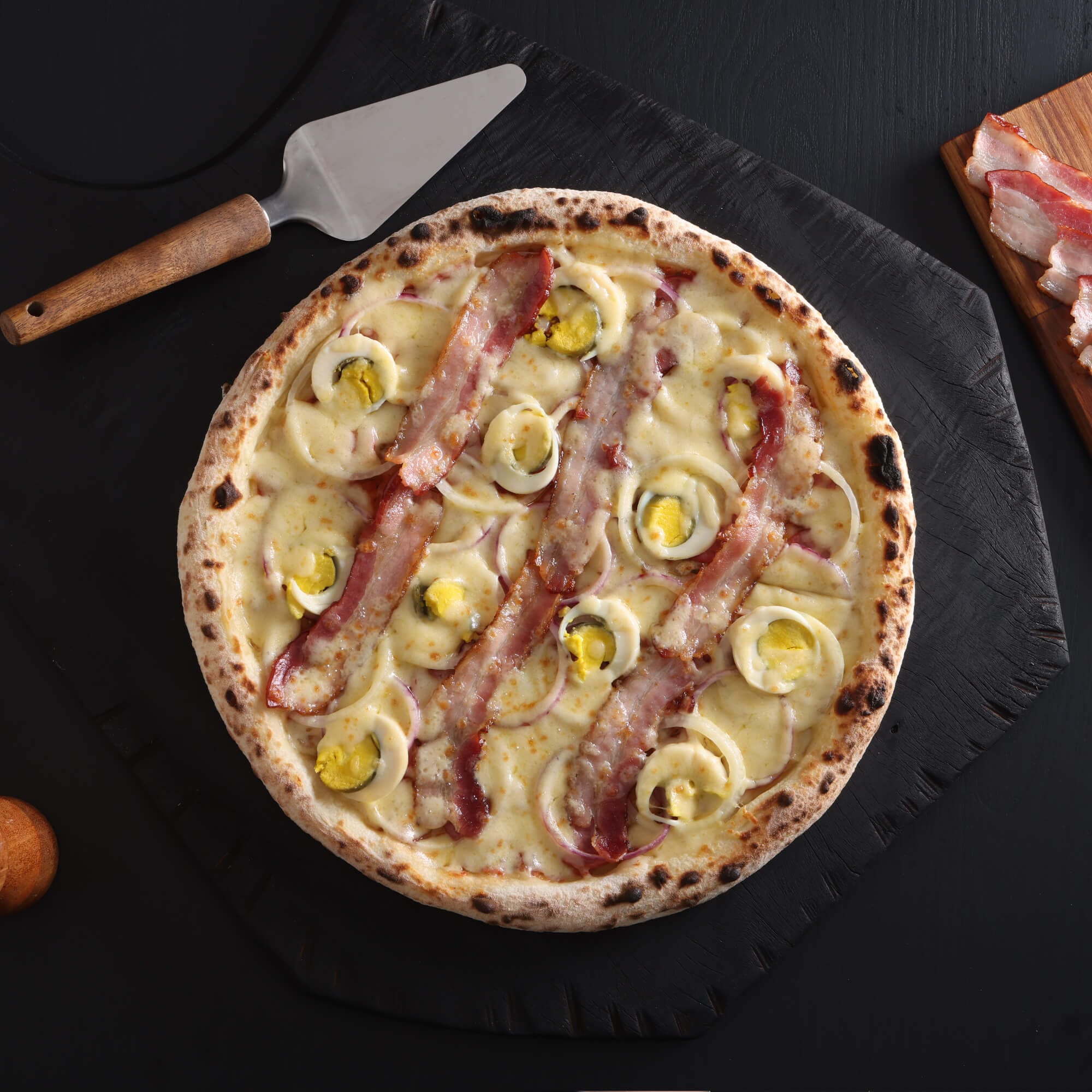 Pizza Americana com calabresa, bacon crocante, ovos e cebola sobre queijo derretido