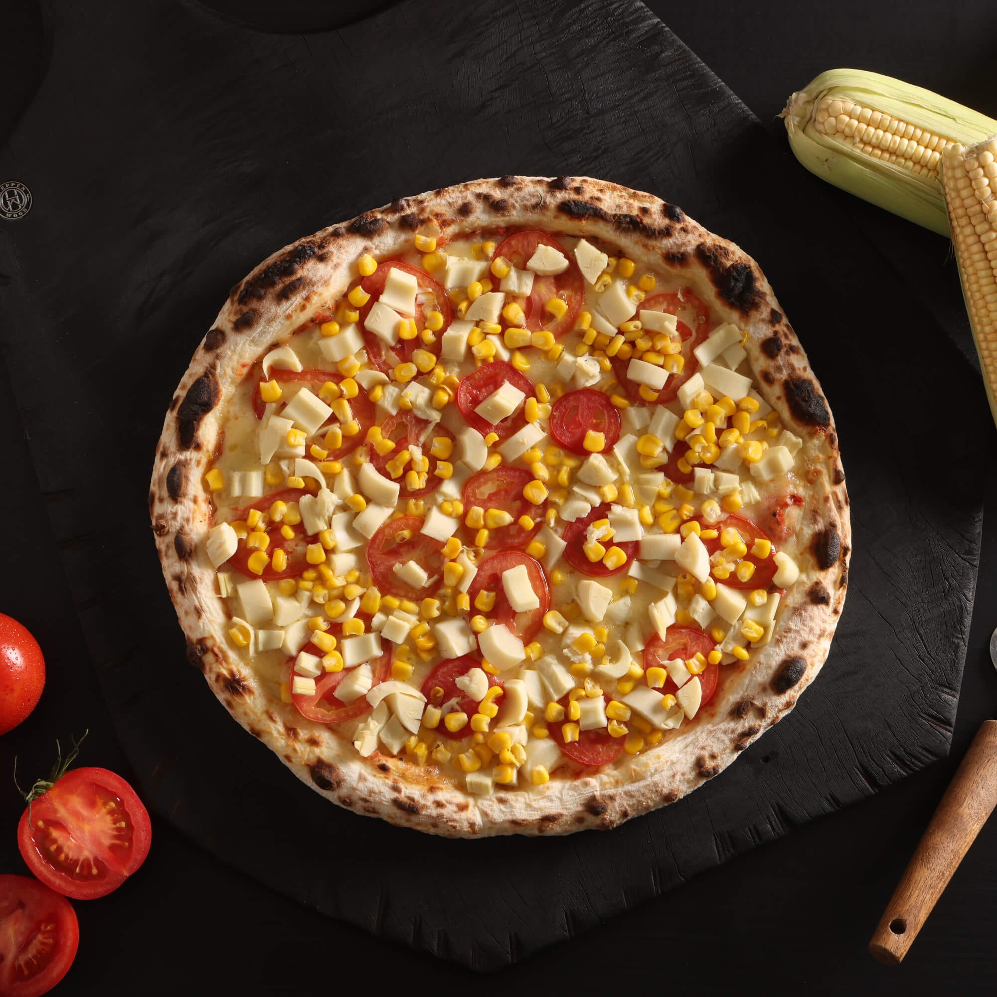 Pizza campestre com massa de fermentação lenta de 48 horas, molho artesanal, queijo derretido, tomate fatiado, milho e palmito.