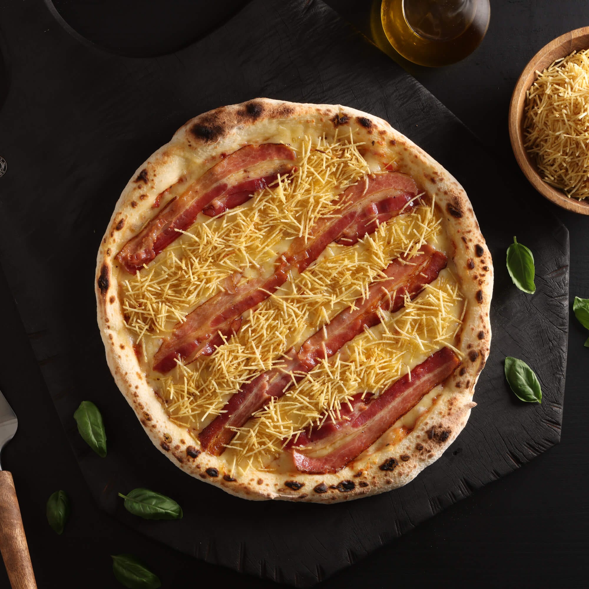Pizza crocante com massa de fermentação lenta de 48 horas, molho artesanal, queijo derretido, bacon em fatias e batata palha.